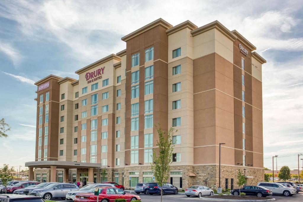 梅森Drury Inn & Suites Cincinnati Northeast Mason的停车场内停放汽车的酒店大楼