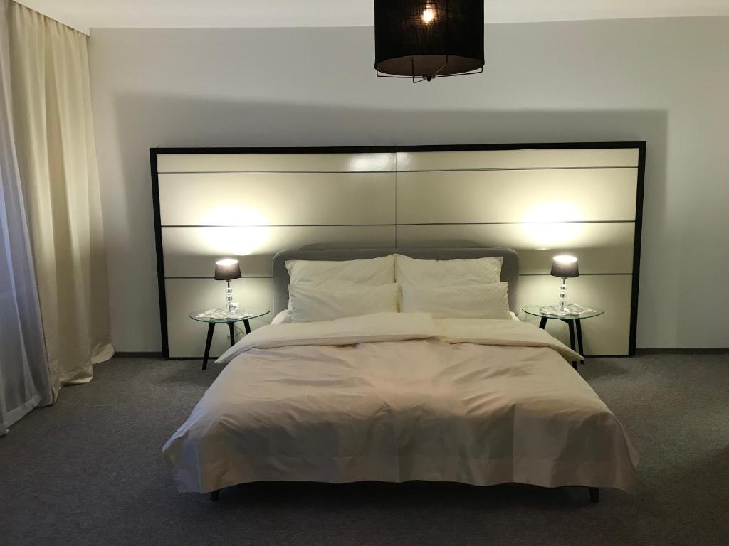 莱布尼茨Charmante Stadtwohnung im Zentrum von Leibnitz的一间卧室配有一张带两盏灯的大型白色床。