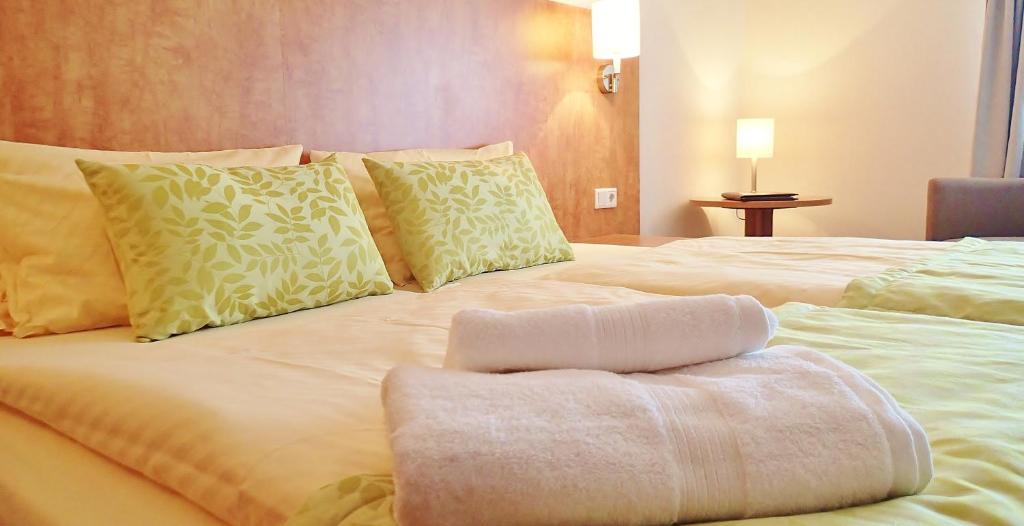 杜塞尔多夫明伽藤酒店的一张白色的大床,上面有毛巾
