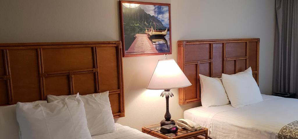 檀香山Imperial Hawaii Resort的酒店客房,设有两张床和一盏灯