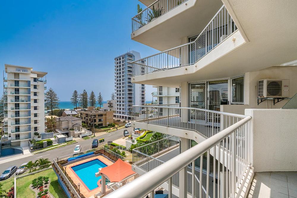 黄金海岸Rainbow Bay Resort Holiday Apartments的享有带游泳池的建筑的空中景致