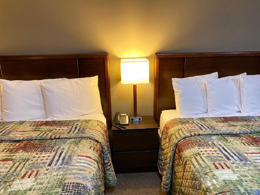 DushoreHotel Dushore的酒店客房,设有两张床和一盏灯
