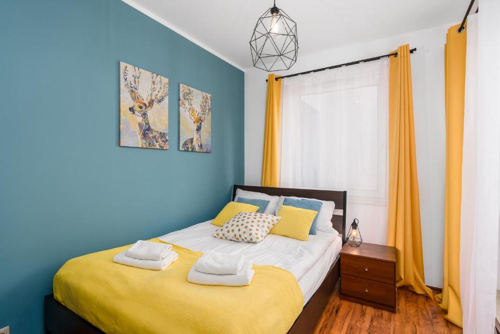 波兹南Sleepway Apartments - Garbary 95-75D的一间卧室设有一张黄色和蓝色墙壁的床