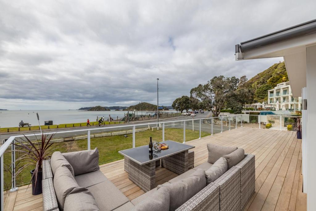 派西亚Waterfront Beach House - Paihia Holiday Home的阳台配有沙发,享有海景。