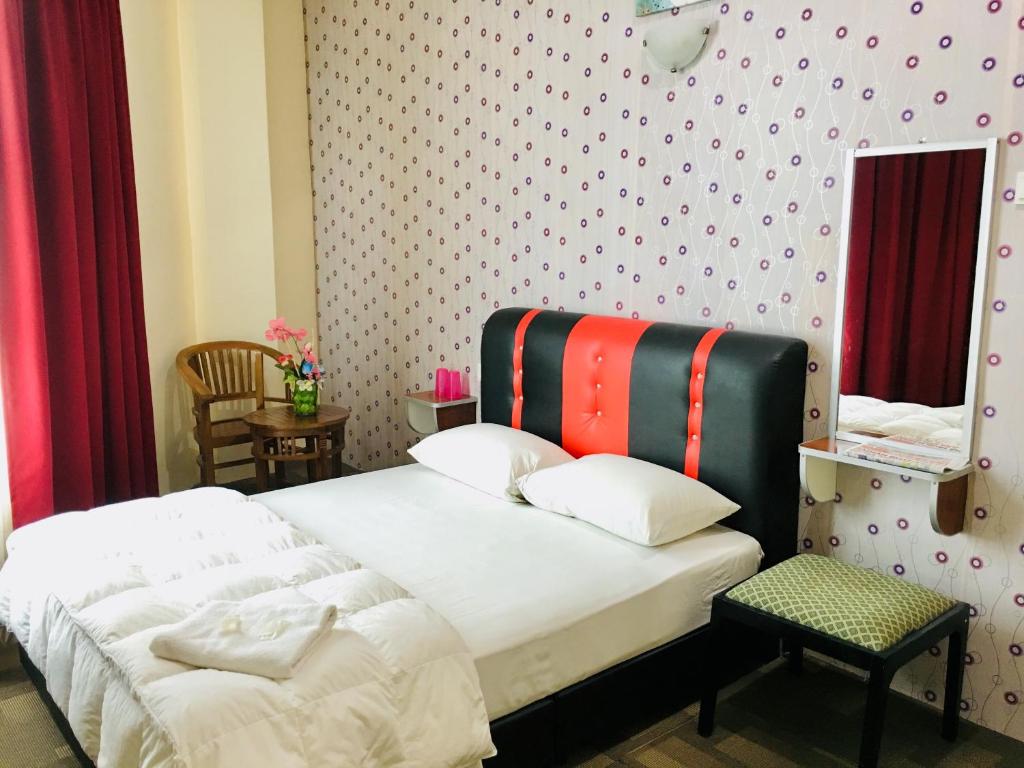 马六甲Hotel Bestari的一间卧室配有一张带色彩缤纷床头板的床