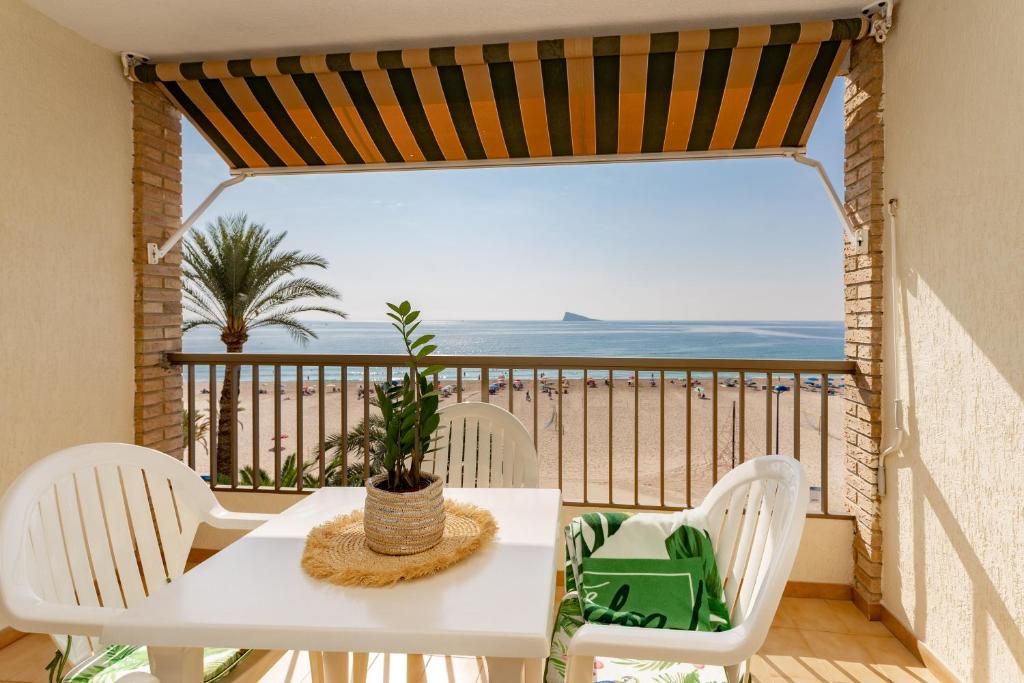 贝尼多姆玛丽亚克里斯蒂娜海滩公寓酒店的阳台上配有白色的桌椅,享有海景