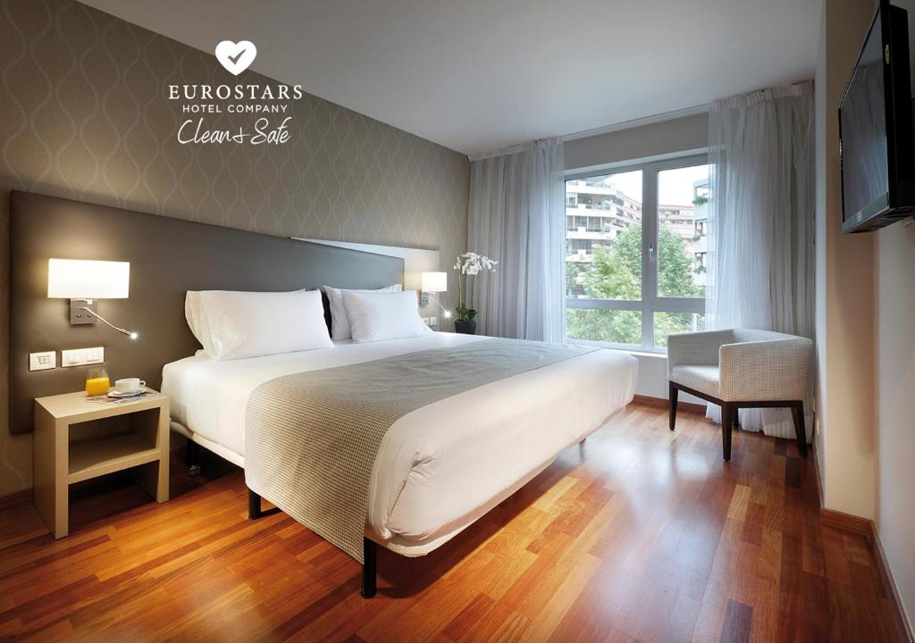 萨拉戈萨WTC埃克萨拉戈萨酒店的一间卧室设有一张大床和一个窗户。