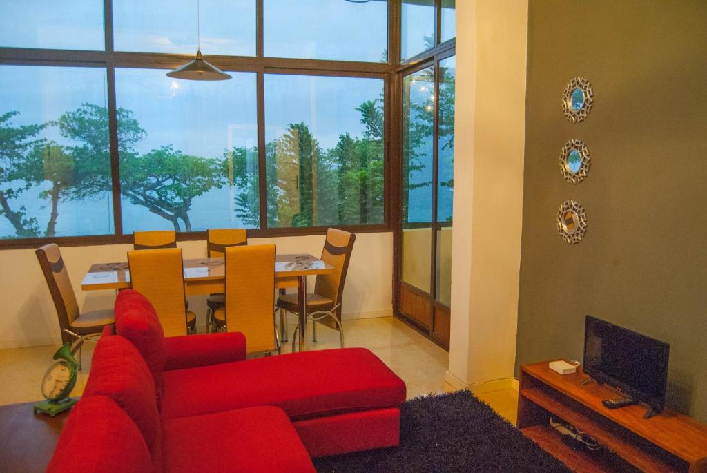圣多美Sky Nautico Apartment的客厅配有红色的沙发和桌子