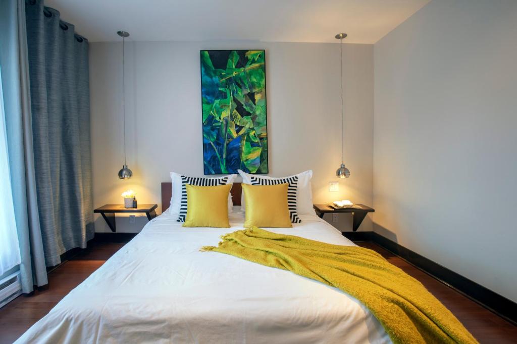 蒙特利尔Lofts Jacques-Cartier Free Parking的卧室配有一张带黄色枕头的大型白色床。