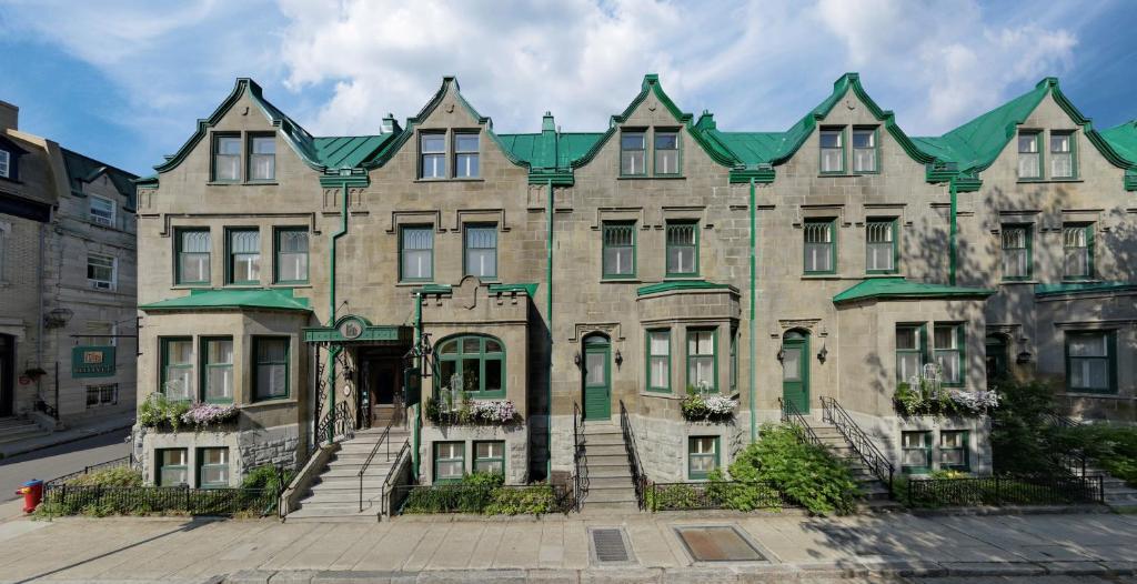 魁北克市贝尔维城堡酒店的一座绿色屋顶的大型石头建筑