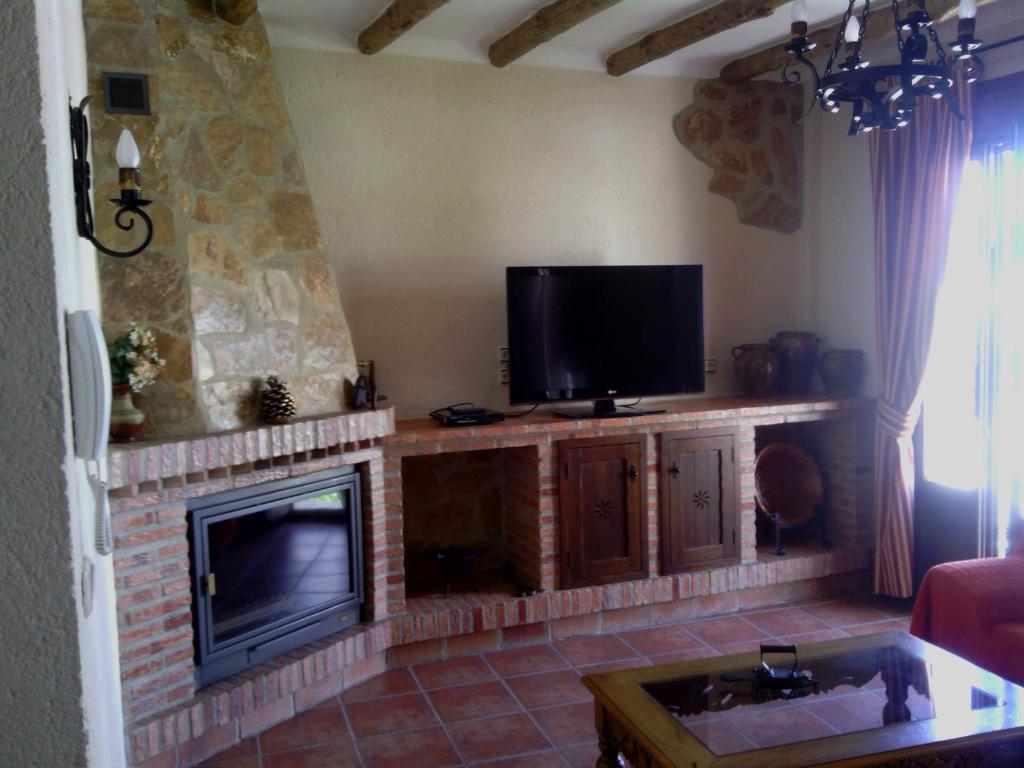 扎哈拉Casa Rural-Apartamento El Lebrillero的客厅设有壁炉和平面电视。