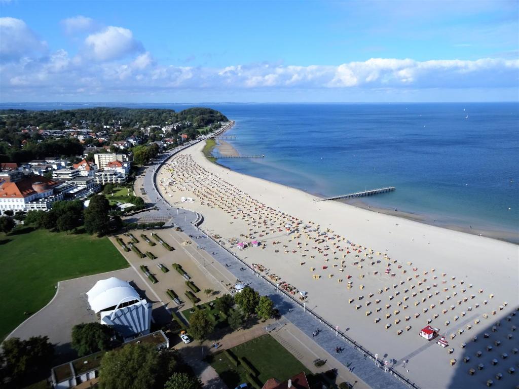 特拉弗明德Apartments Villa Seeblick Travemünde的享有海滩的空中景致,配有椅子和遮阳伞