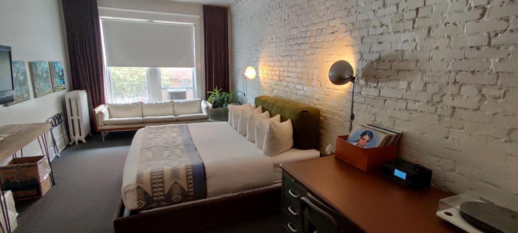 西雅图埃斯酒店西雅图的一间卧室设有一张大床和砖墙