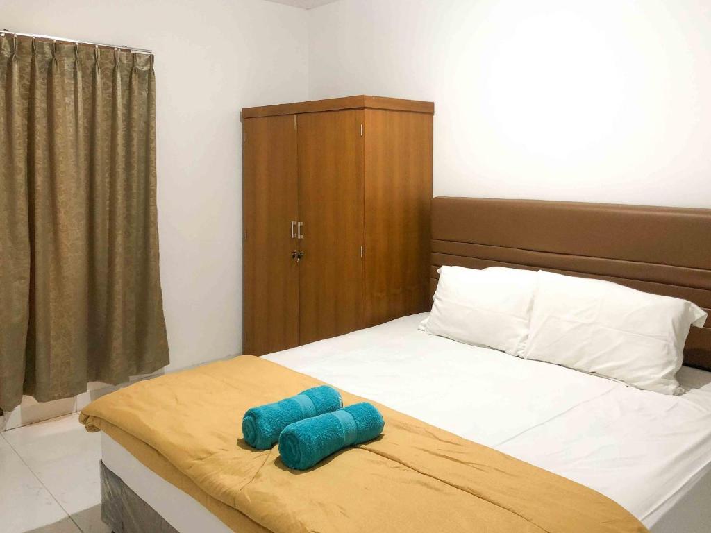 玛琅Sofia Residence Syariah Mitra RedDoorz的床上有2个蓝色枕头