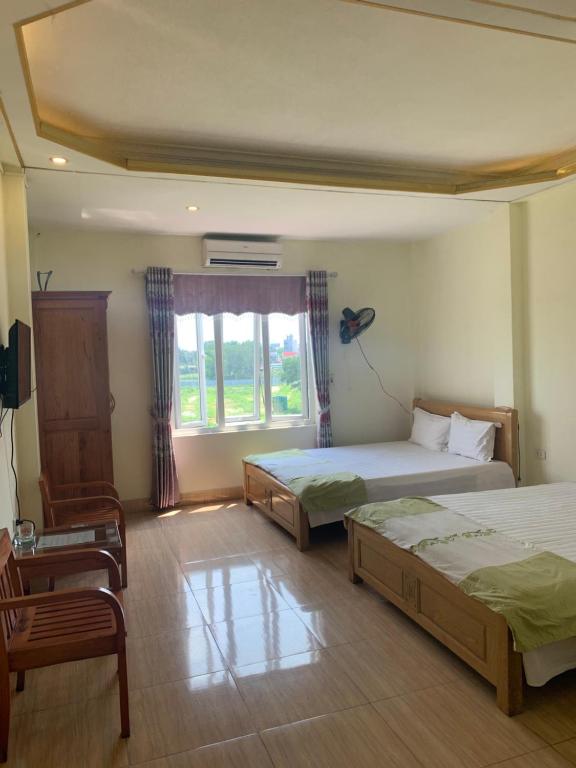 河内Nhà nghỉ Diễm Quỳnh Nội Bài的一间卧室设有两张床和窗户。