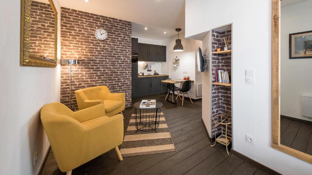 勒芒L'Atelier fil à fil的客厅设有黄色椅子和砖墙