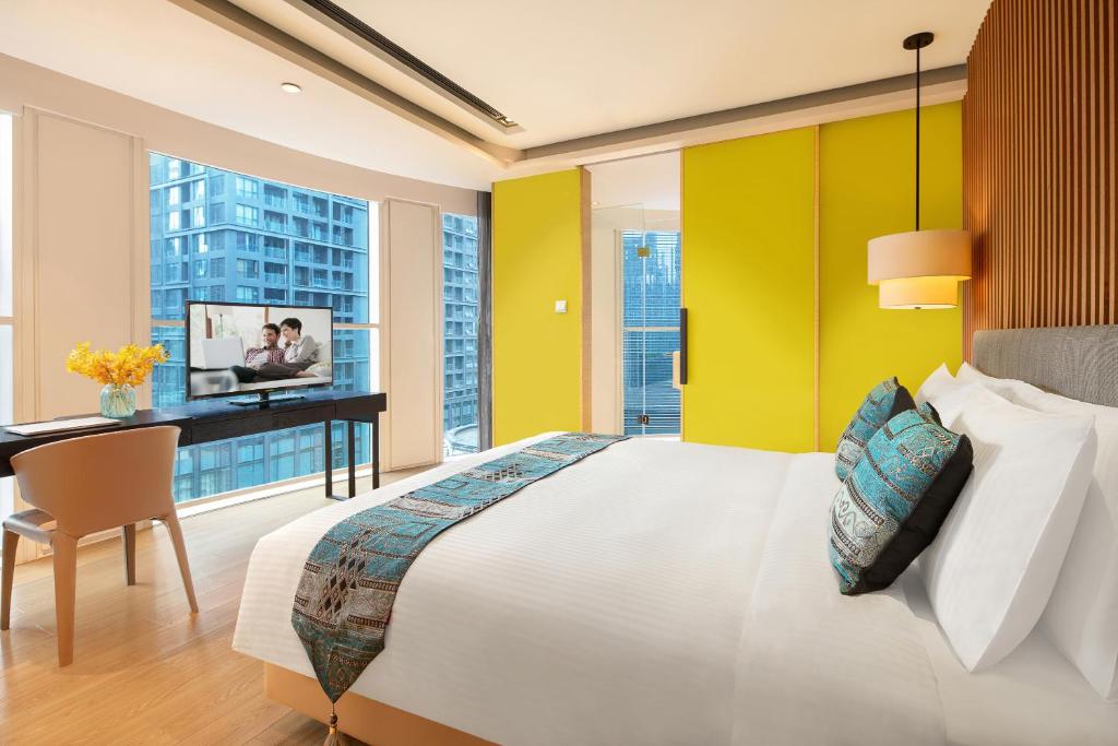 成都成都馨乐庭城南公寓酒店的一间卧室配有一张大床、一张书桌和窗户。