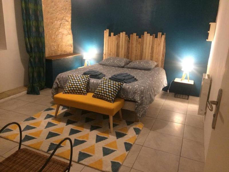 勒比格Appartement 2 personnes Le Bugue Périgord Noir的一间卧室配有一张带两盏灯和地毯的床。
