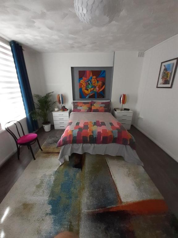 伦敦BIG BEN'S SHADE的一间卧室配有一张带五颜六色棉被的床