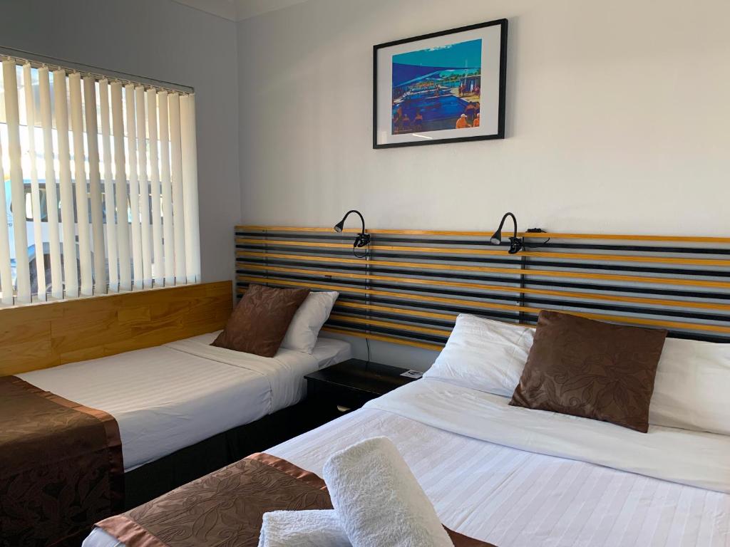 莫里莫里巴斯汽车旅馆的酒店客房设有两张床,墙上挂着一张照片。