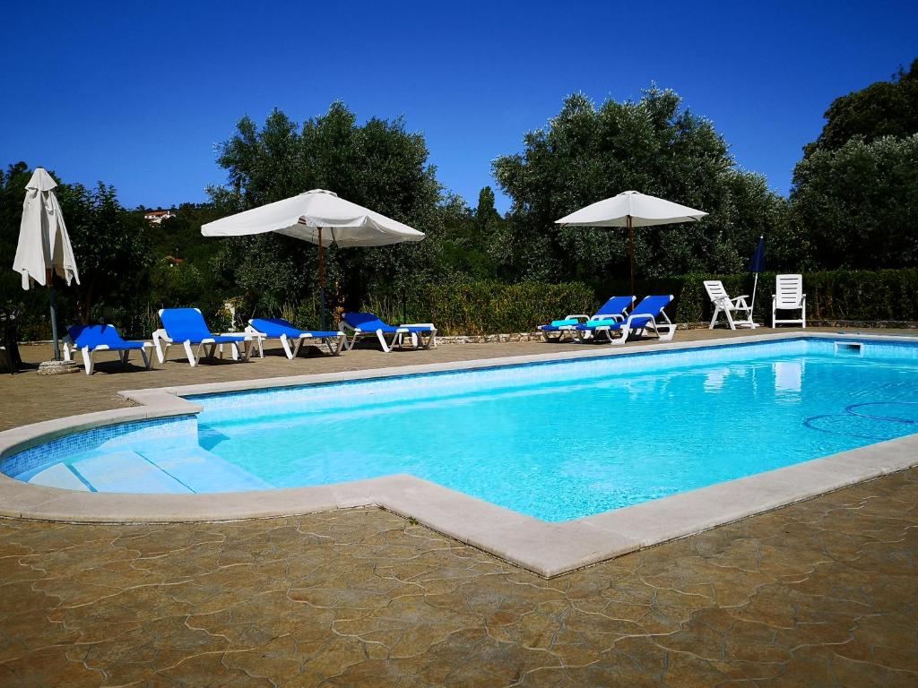 FormigaisCasal do Morgado, country house to relax的一个带蓝色椅子和遮阳伞的游泳池