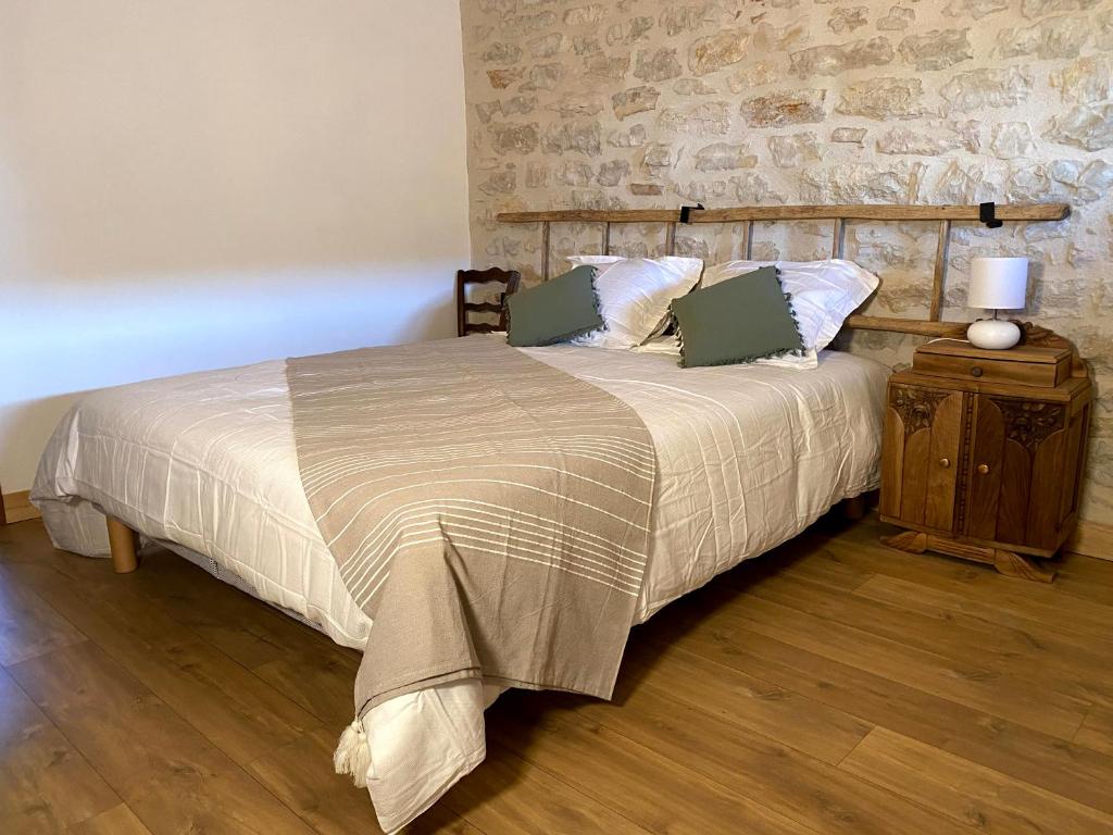 CousanceClos De La Charnaille的一间卧室设有一张床和石墙