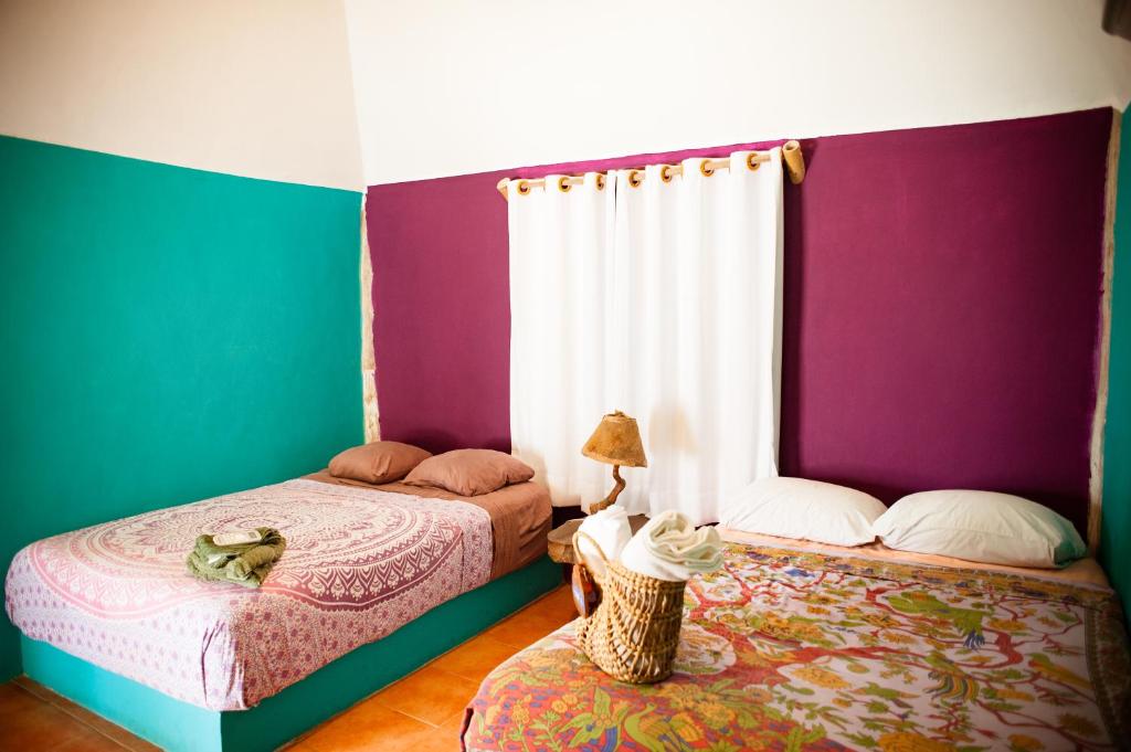 玛哈威Nacional Beach Club & Bungalows的紫绿色客房内的两张床
