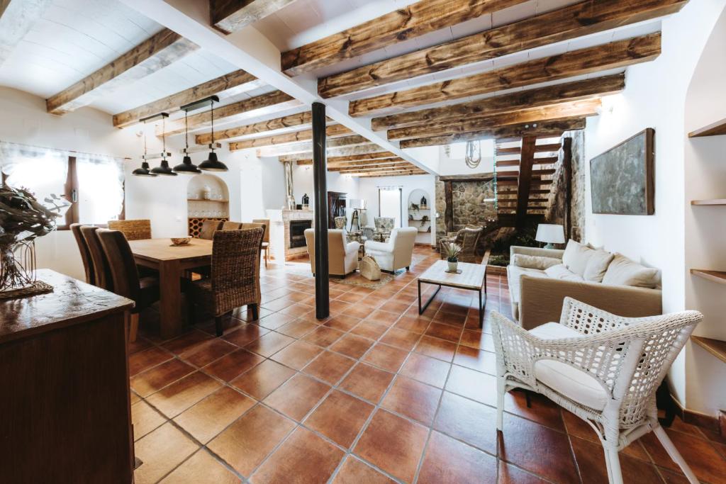 Villavieja del LozoyaPosada del tiempo的客厅设有木制天花板和桌椅
