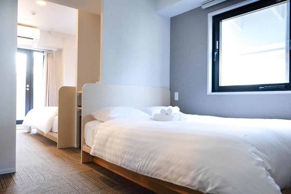 东京The Light Inn - Vacation STAY 94706的卧室设有一张白色大床和一扇窗户。