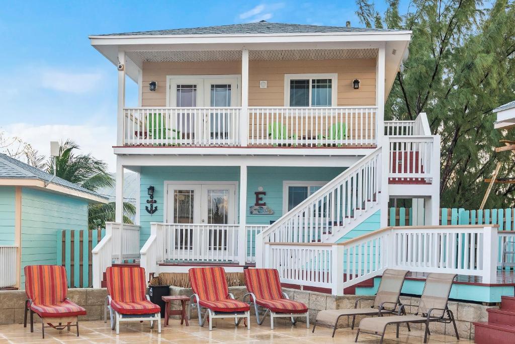 Staniel CayEMBRACE Resort的房屋前方设有甲板和椅子