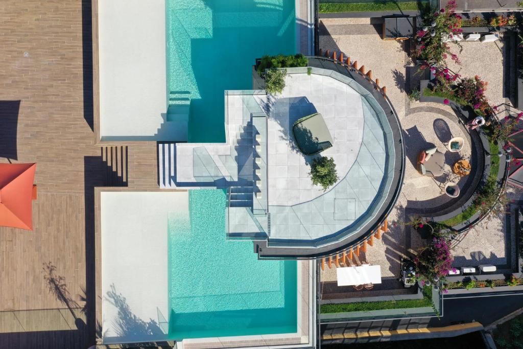 丰沙尔Three House Hotel的大楼旁游泳池的顶部景色