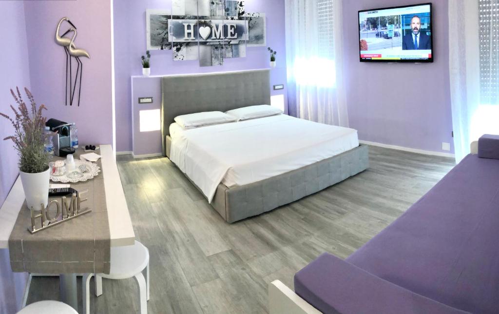 博洛尼亚BB Veronesi的紫色卧室配有一张床和一张桌子