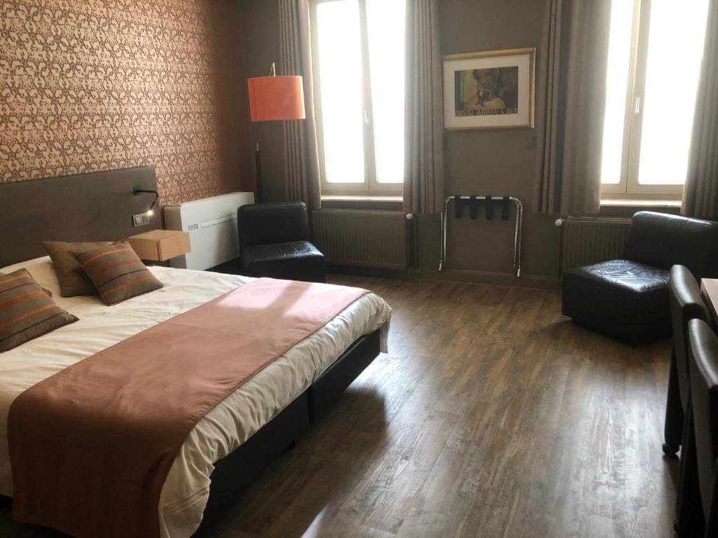 科特赖克Hotel Duivels Paterke Harelbeeksestraat 29, 8500 Kortrijk的一间卧室配有一张大床和两把椅子