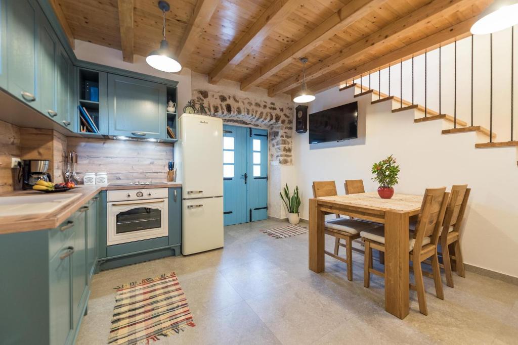 奈维丹Holiday Home Lipa Naša的厨房配有蓝色橱柜、餐桌和用餐室