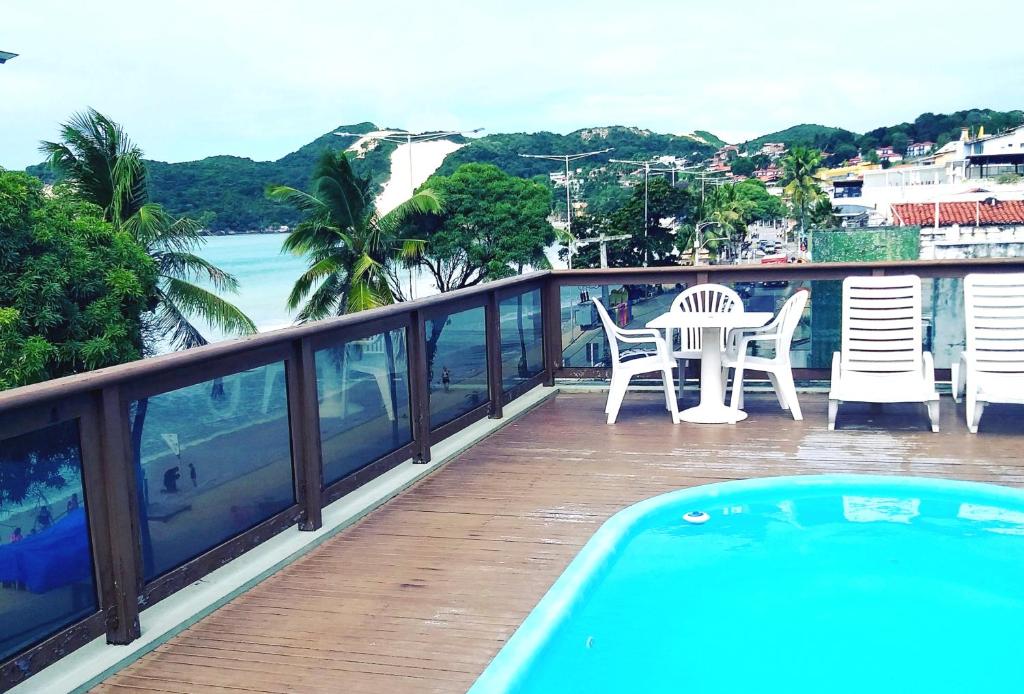 纳塔尔Bella Natal Praia Hotel的一个带桌椅的阳台和一个游泳池