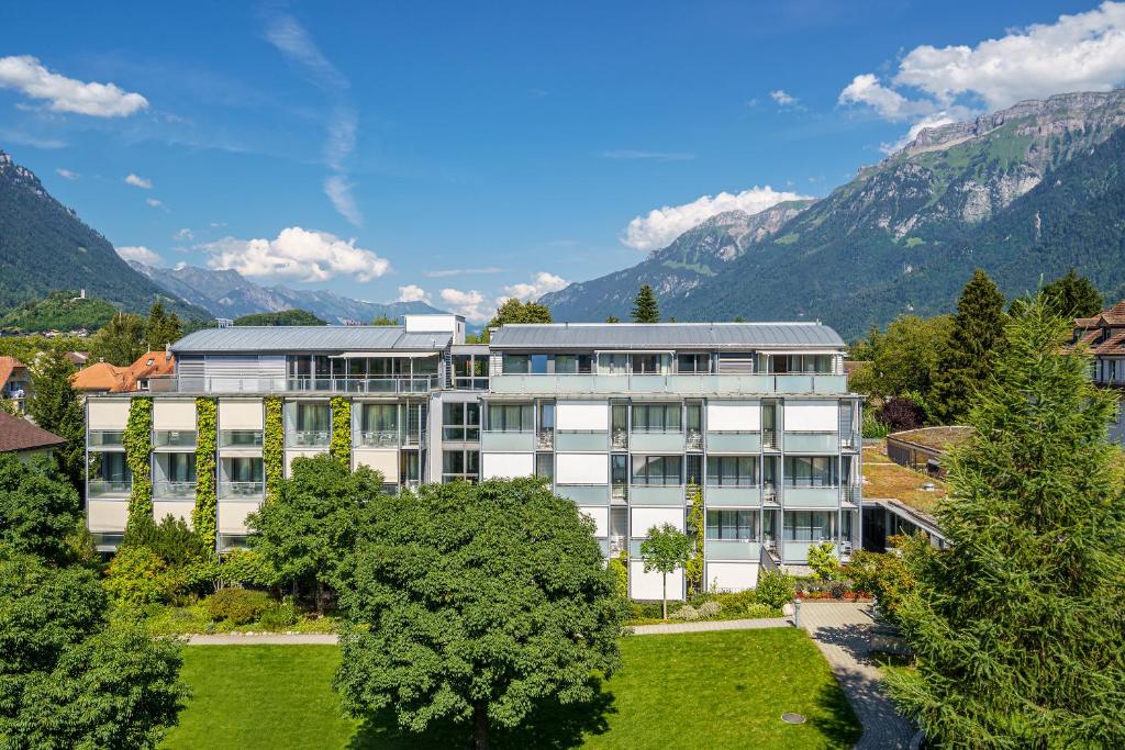 因特拉肯Hotel Artos Interlaken的山地建筑的背景图象