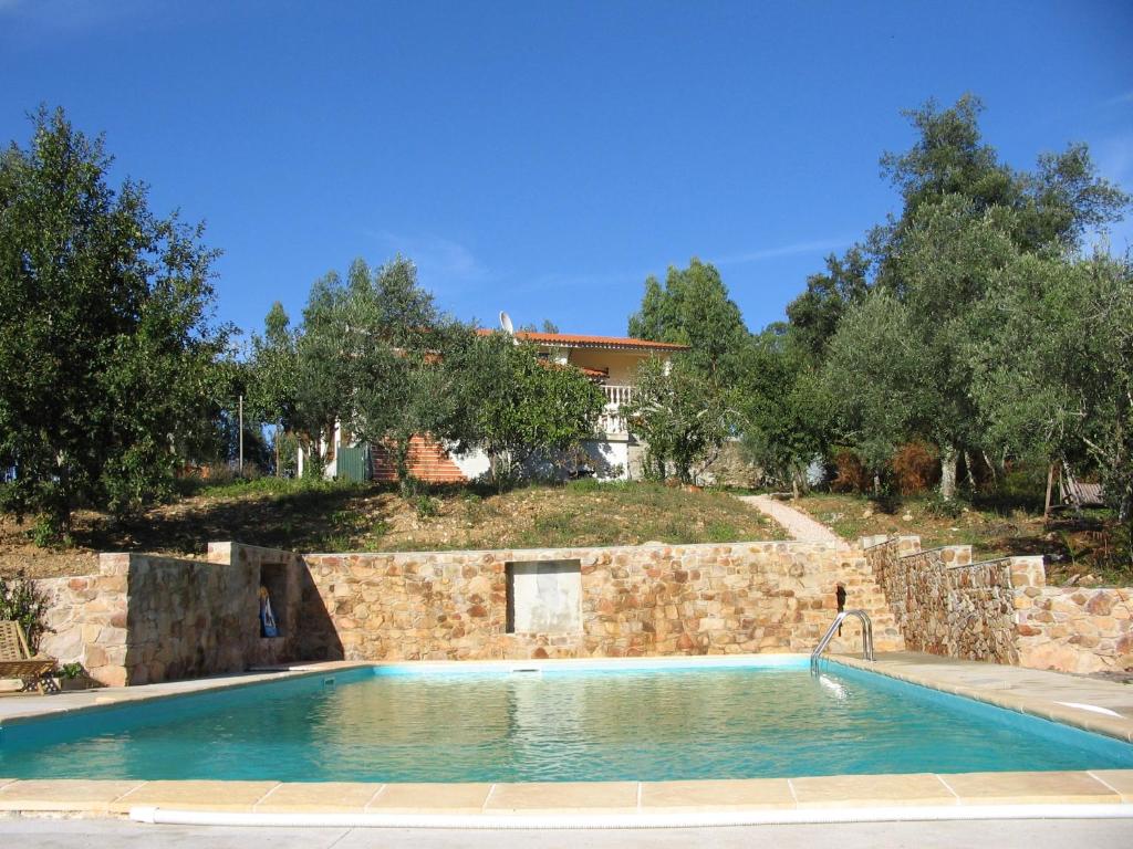 波亚里什新镇Quinta no Pinhal的石头墙前的游泳池