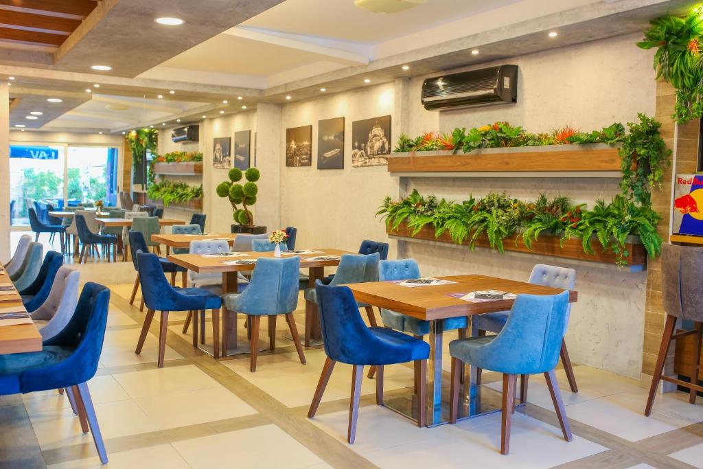 贝尔格莱德Hotel City Code Vizura garni RENEW的餐厅设有木桌和蓝色椅子