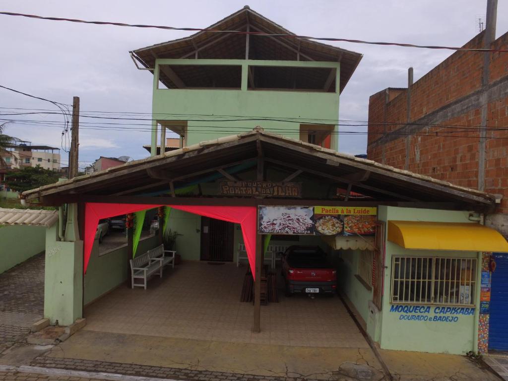 伊塔奥卡Pousada Portal da Ilha的前面有红色天篷的建筑