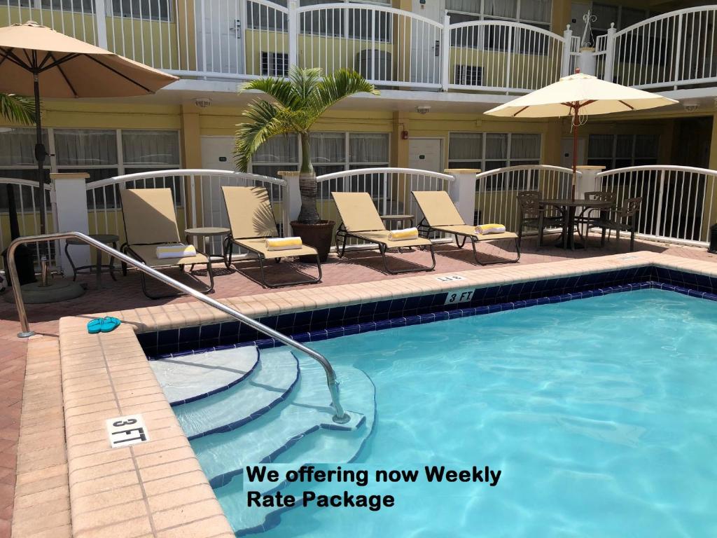 迈阿密海滩海滩广场酒店的一座带椅子和遮阳伞的游泳池