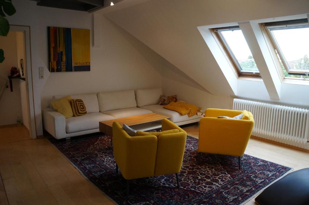 Orth an der DonauFerienwohnung Donauauen的客厅配有沙发和2把黄色椅子