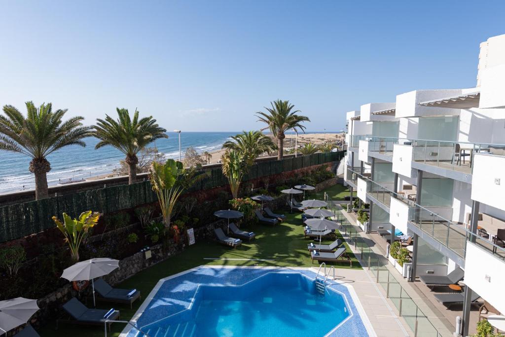 圣巴托洛梅TERRAZAMAR的从酒店阳台可欣赏到游泳池和海滩的景色