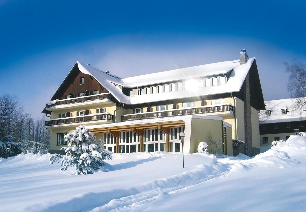 舍内克Hotel Haus am Ahorn的前面有大雪的建筑