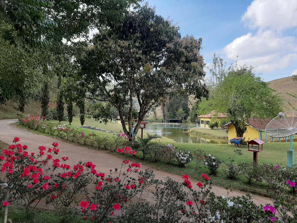 蒙特罗洛巴托Chalés Tia Nastácia的一个带游乐场、鲜花和池塘的公园