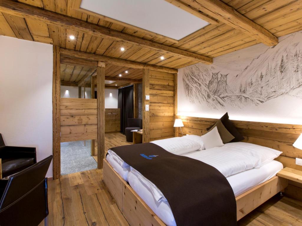 策尔内茨策尔内茨克劳斯酒店的一间带一张大床的卧室,位于带木墙的房间
