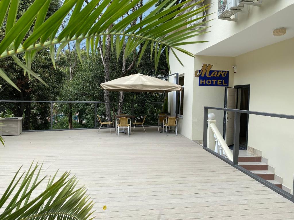 索契Maro Hotel的庭院配有遮阳伞和桌椅。