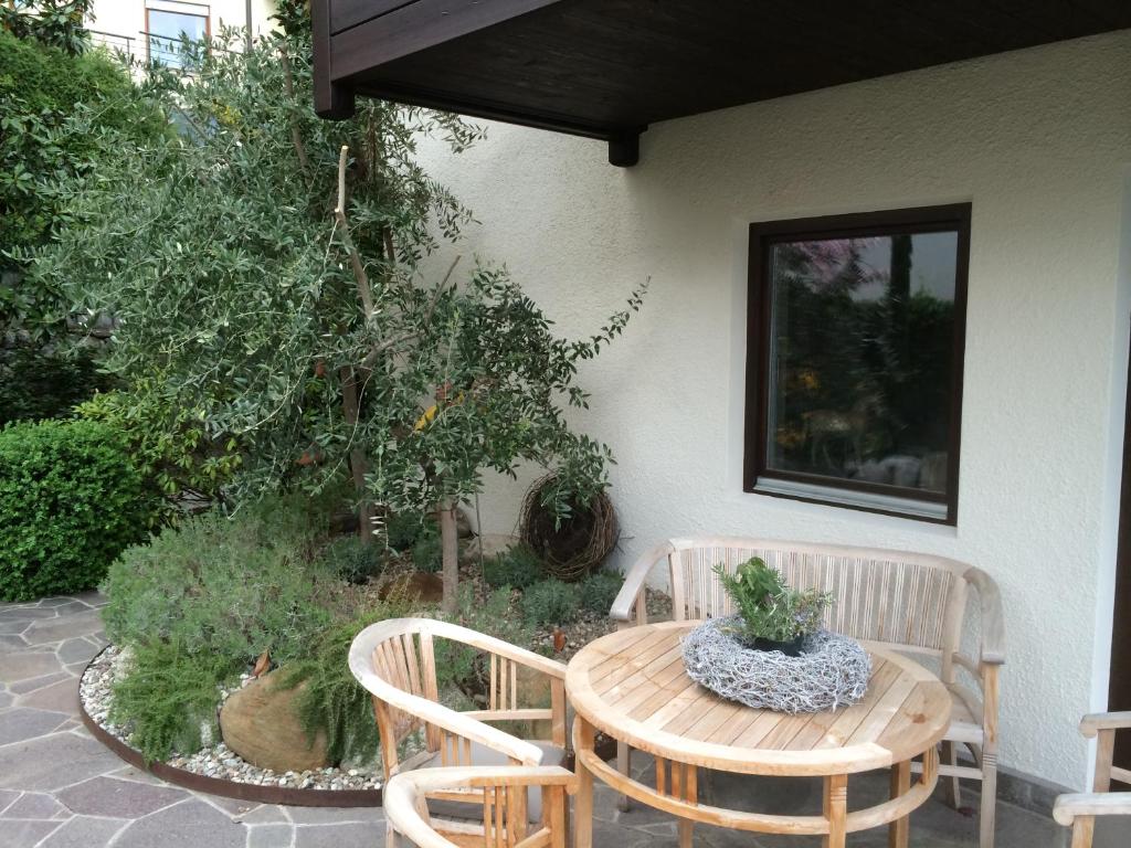 拉古多Pension Hauenstein的庭院配有桌子、两把椅子和桌椅