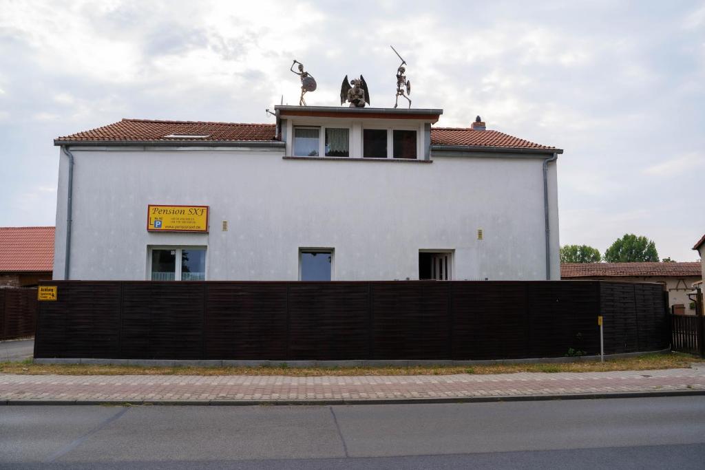 舍讷费尔德SXF膳食公寓的两座雕像上方的白色建筑
