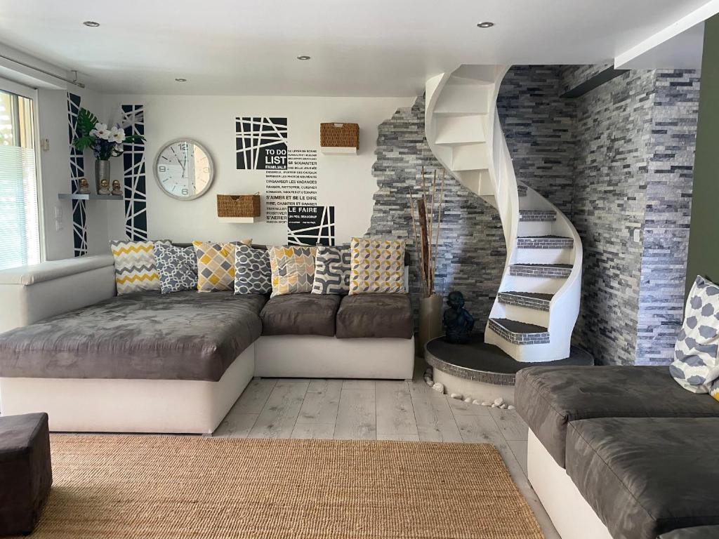 奥比格诺克La Salamandre de l Olivier - le Mimosa的带沙发和螺旋楼梯的客厅