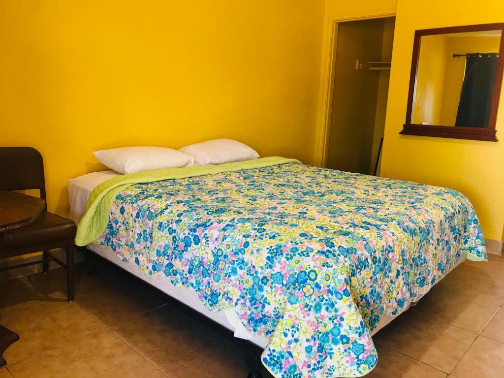 奥克兰海军准将汽车旅馆的一间卧室配有一张带五颜六色棉被的床